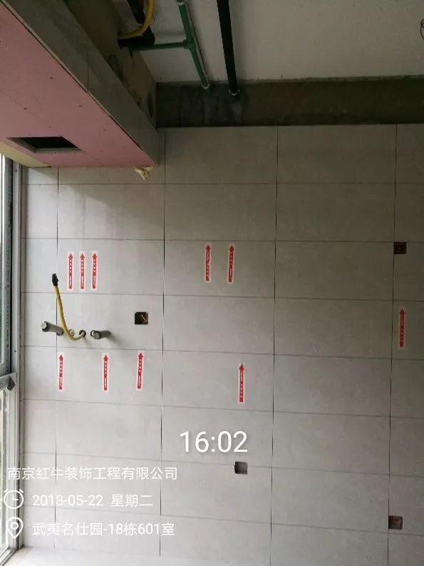 南京武夷名仕園124平米簡(jiǎn)美風(fēng)格裝修  享受家?guī)?lái)的溫度30五月份_墻磚鋪貼完成后，紅牛裝飾的工人會(huì)用專用護(hù)角條對(duì)瓷磚角保護(hù)，用標(biāo)貼標(biāo)出水管、線管走向示意。
